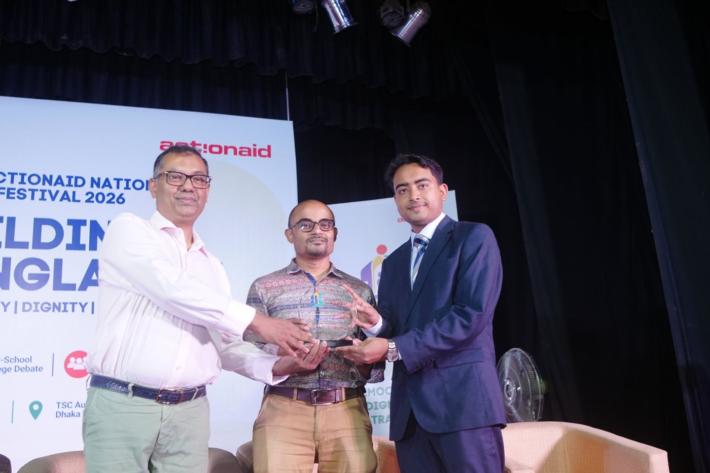 Shazid receiving a crest on stage